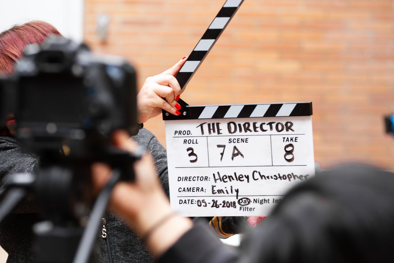 Close-up of film clapperboard in action with camera filming a take on set.